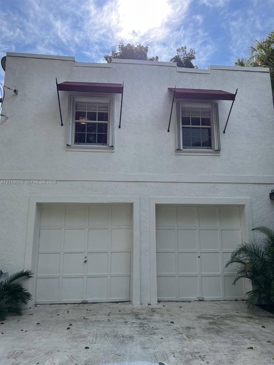 11728 NE 6th Avenue, #2, Biscayne Park, Biscayne Park, FL 33161 Stucco exterior facade featuring two garage bays, multi-pane windows, and metal awnings