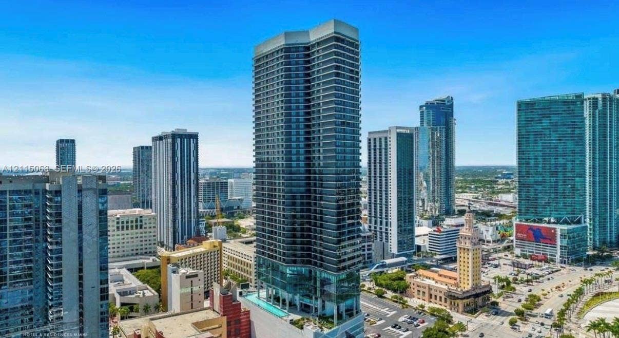 High-rise residential tower featuring a glass facade, private balconies, and an elevated outdoor swimming pool