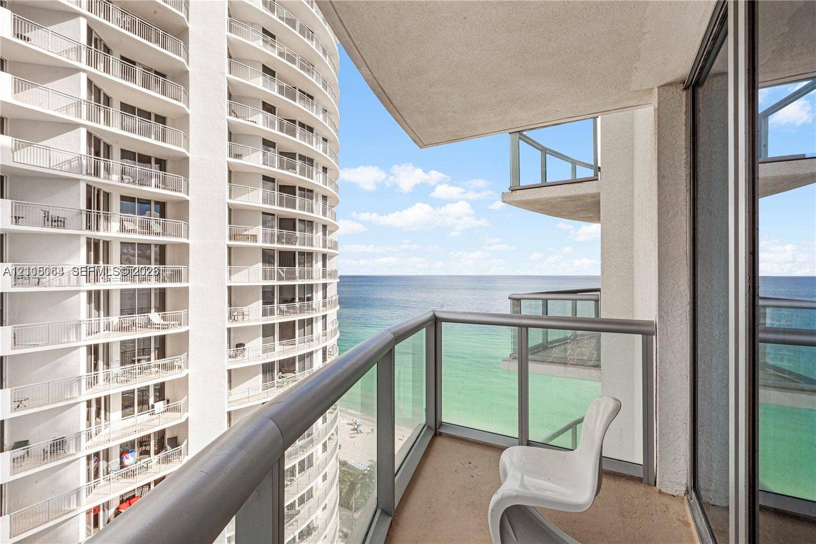 17315 Collins Avenue, #1808, Sunny Isles Beach, FL 33160 Covered balcony with glass and metal railings, concrete flooring, and panoramic ocean expanse