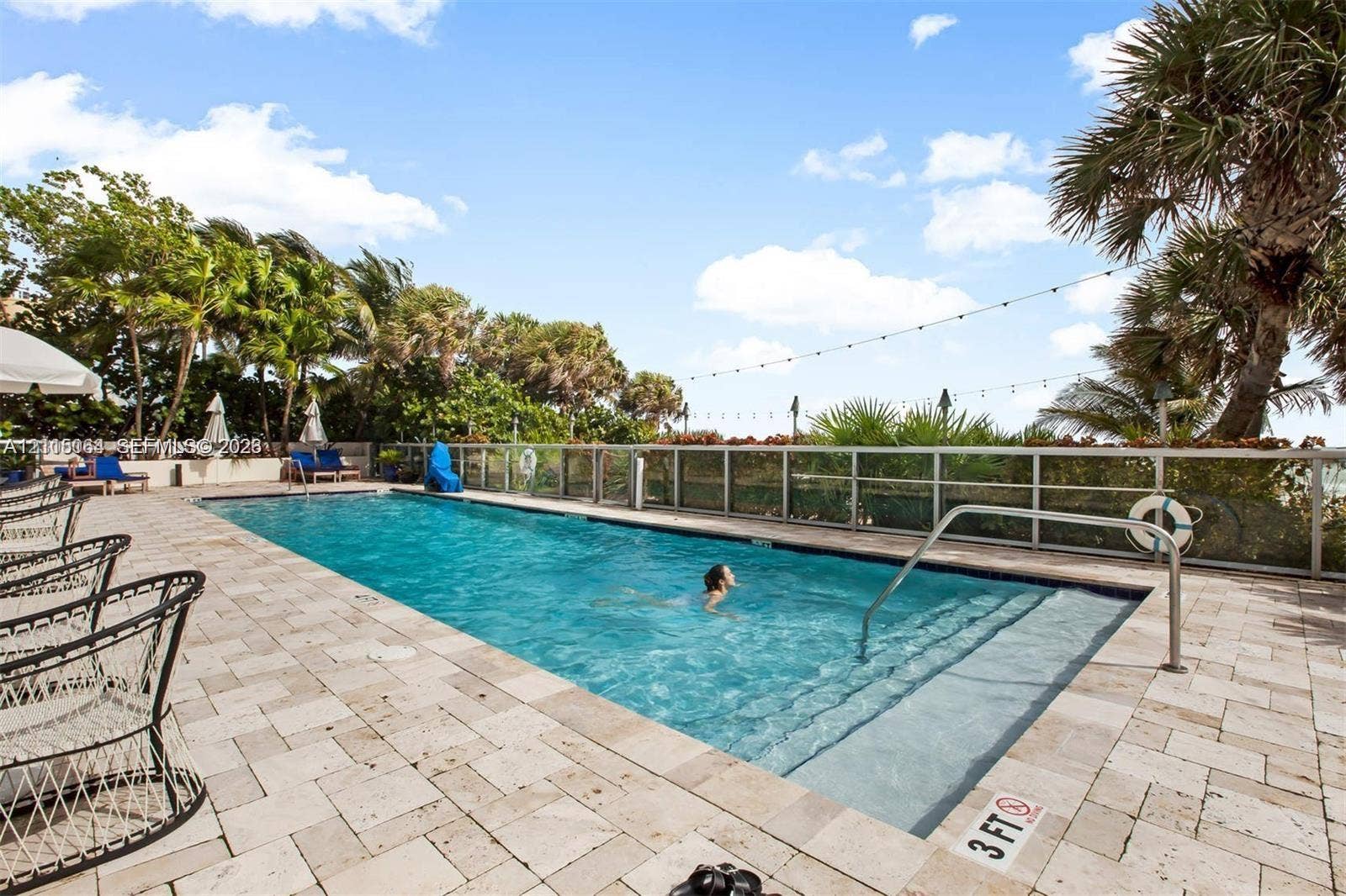 17315 Collins Avenue, #1808, Sunny Isles Beach, FL 33160 Rectangular in-ground swimming pool featuring stone-paver decking, perimeter metal fencing, and built-in entry steps