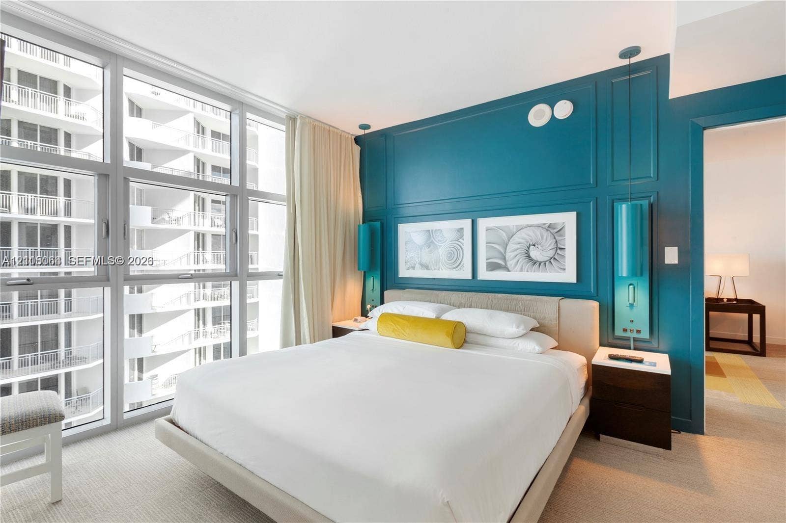 17315 Collins Avenue, #1808, Sunny Isles Beach, FL 33160 Floor-to-ceiling glass windows, custom teal paneling, and wall-mounted cylindrical light fixtures
