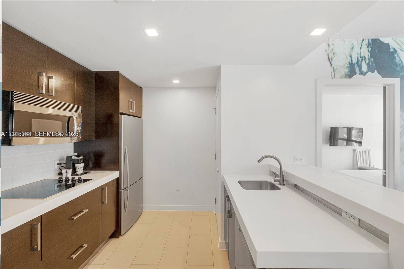 17315 Collins Avenue, #1808, Sunny Isles Beach, FL 33160 Kitchen featuring wood-finish cabinetry, stainless steel appliances, flat-panel countertops, recessed lighting, and tile flooring