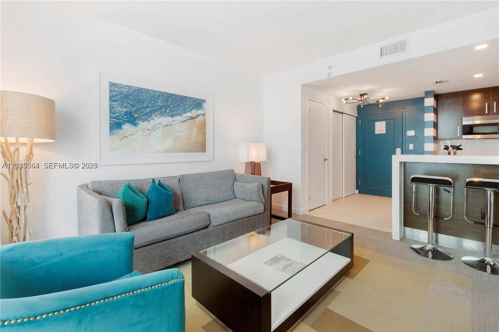 17315 Collins Avenue, #1808, Sunny Isles Beach, FL 33160 Open-concept space featuring dark wood-finish cabinetry, a white countertop breakfast bar, recessed lighting, and wall-to-wall carpeting