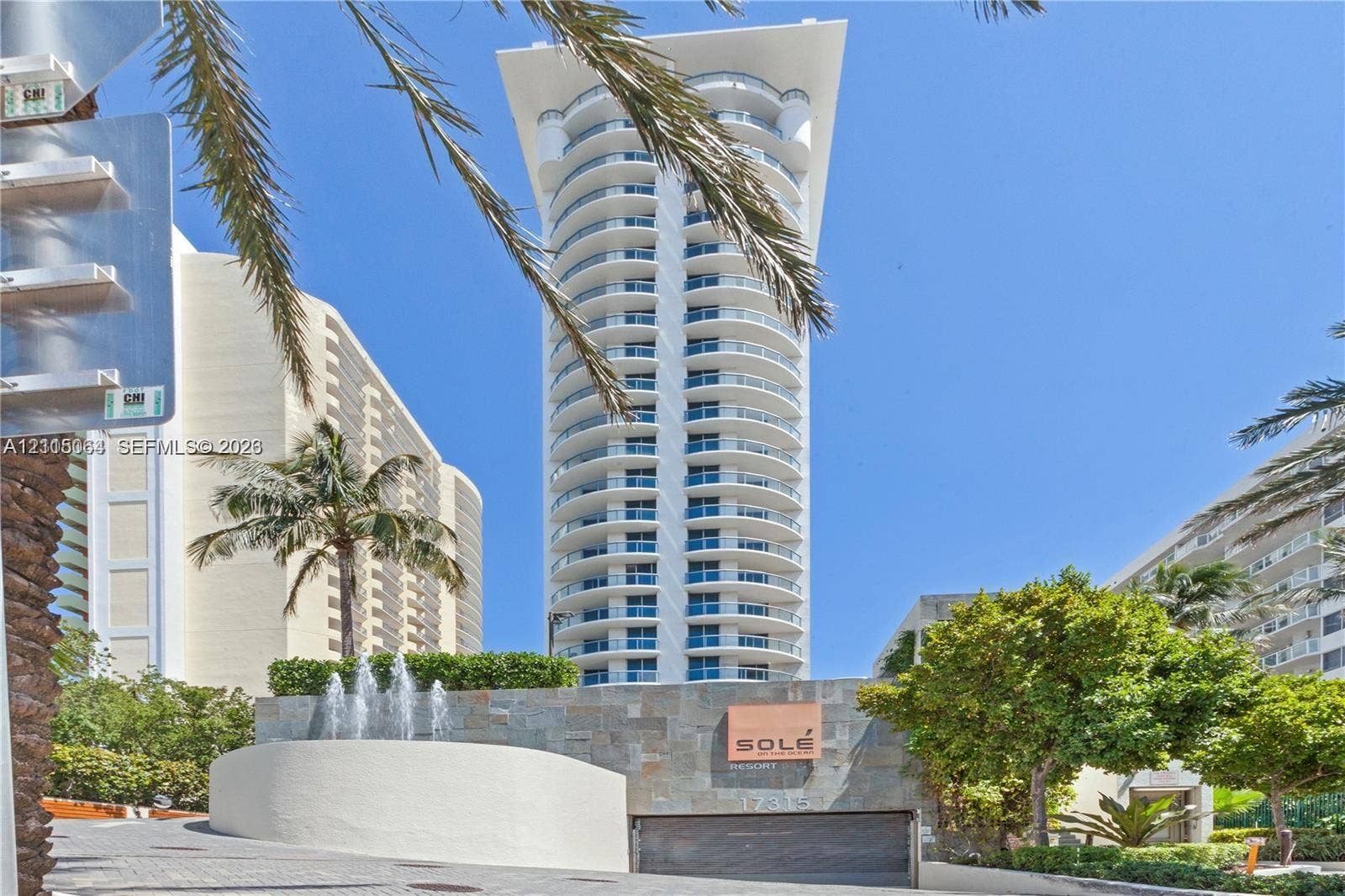 17315 Collins Avenue, #1808, Sunny Isles Beach, FL 33160 High-rise exterior featuring curved structural balconies, stone-clad entrance wall, and tiered water feature