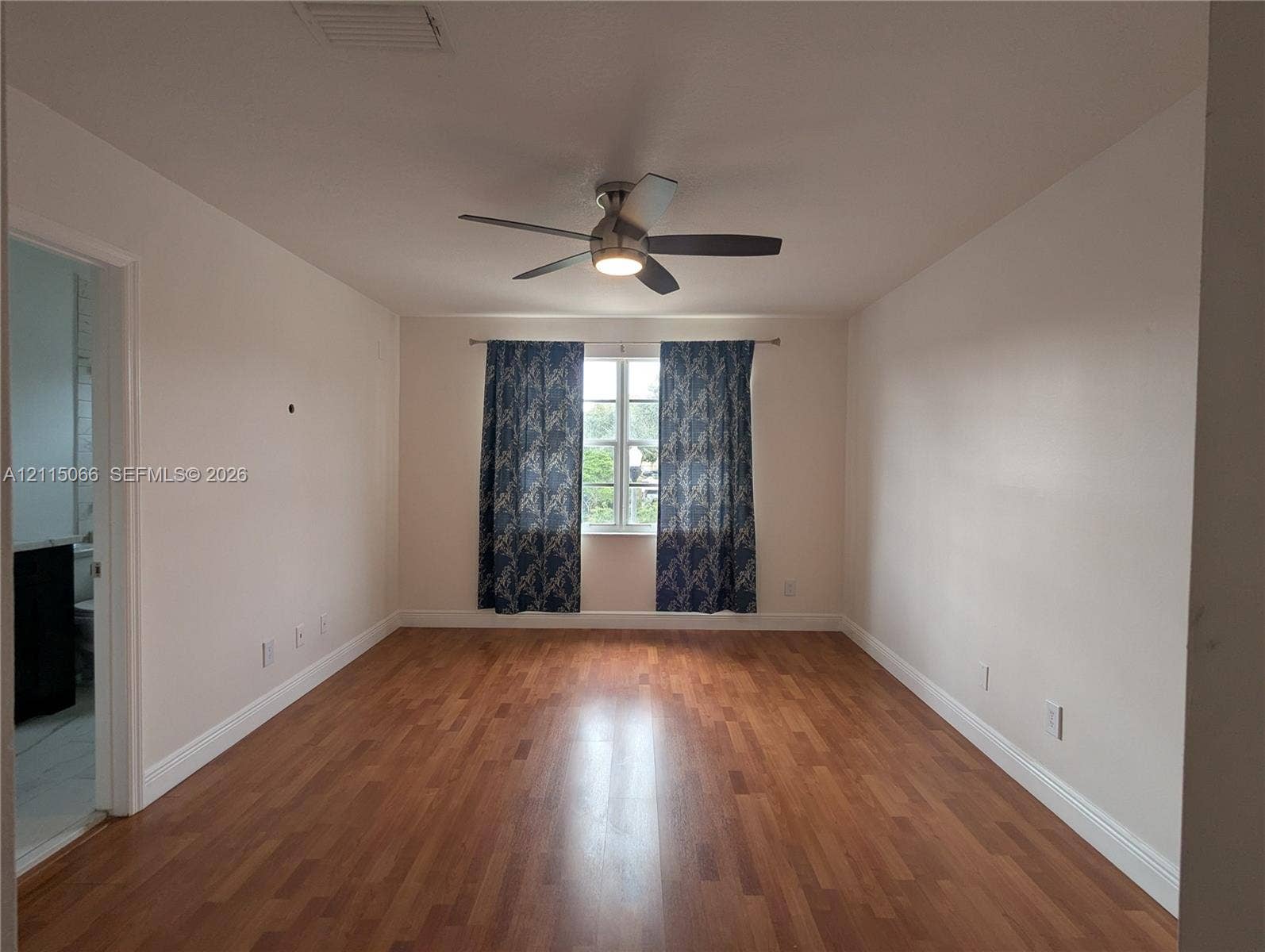 215 SW 120th Avenue, #215, Pembroke Pines, Pembroke Pines, FL 33025 Interior space featuring wood-finish flooring, a neutral color palette, a centrally mounted ceiling fan with integrated lighting, and a single-pane window