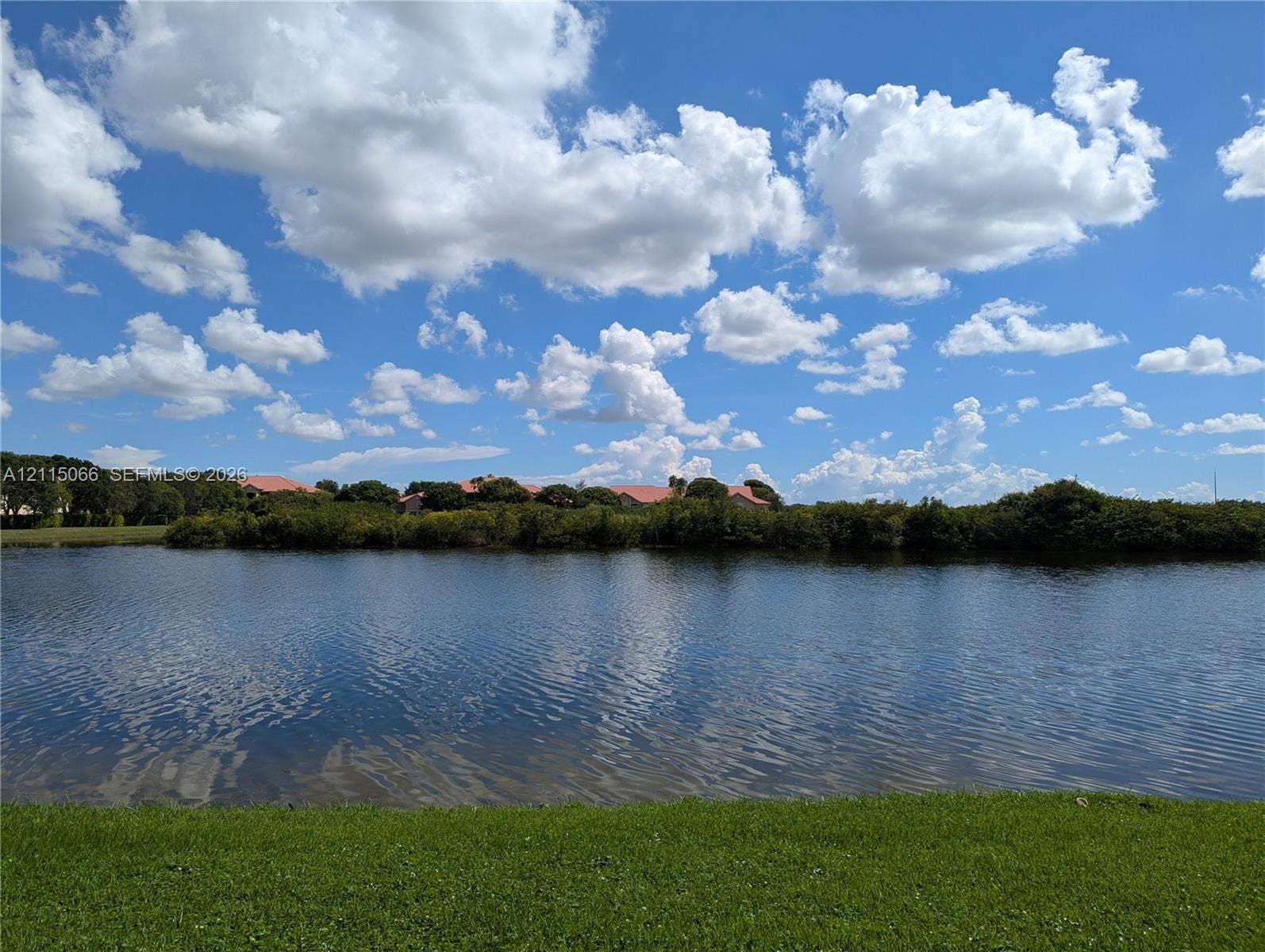 215 SW 120th Avenue, #215, Pembroke Pines, Pembroke Pines, FL 33025 Waterfront property featuring a manicured lawn, expansive pond, and mature landscape