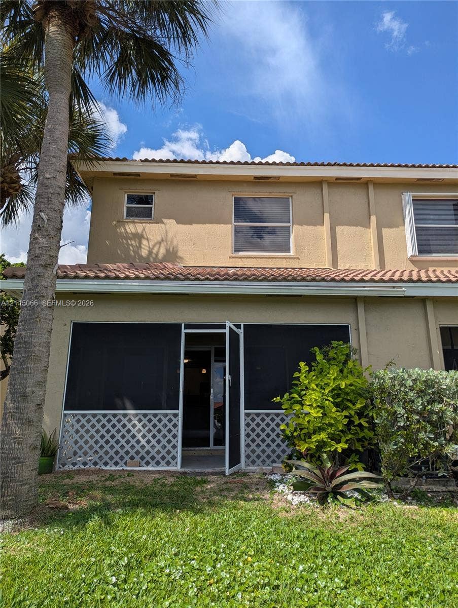 215 SW 120th Avenue, #215, Pembroke Pines, Pembroke Pines, FL 33025 Stucco exterior featuring a screened-in patio, decorative lattice skirting, and a tile roof