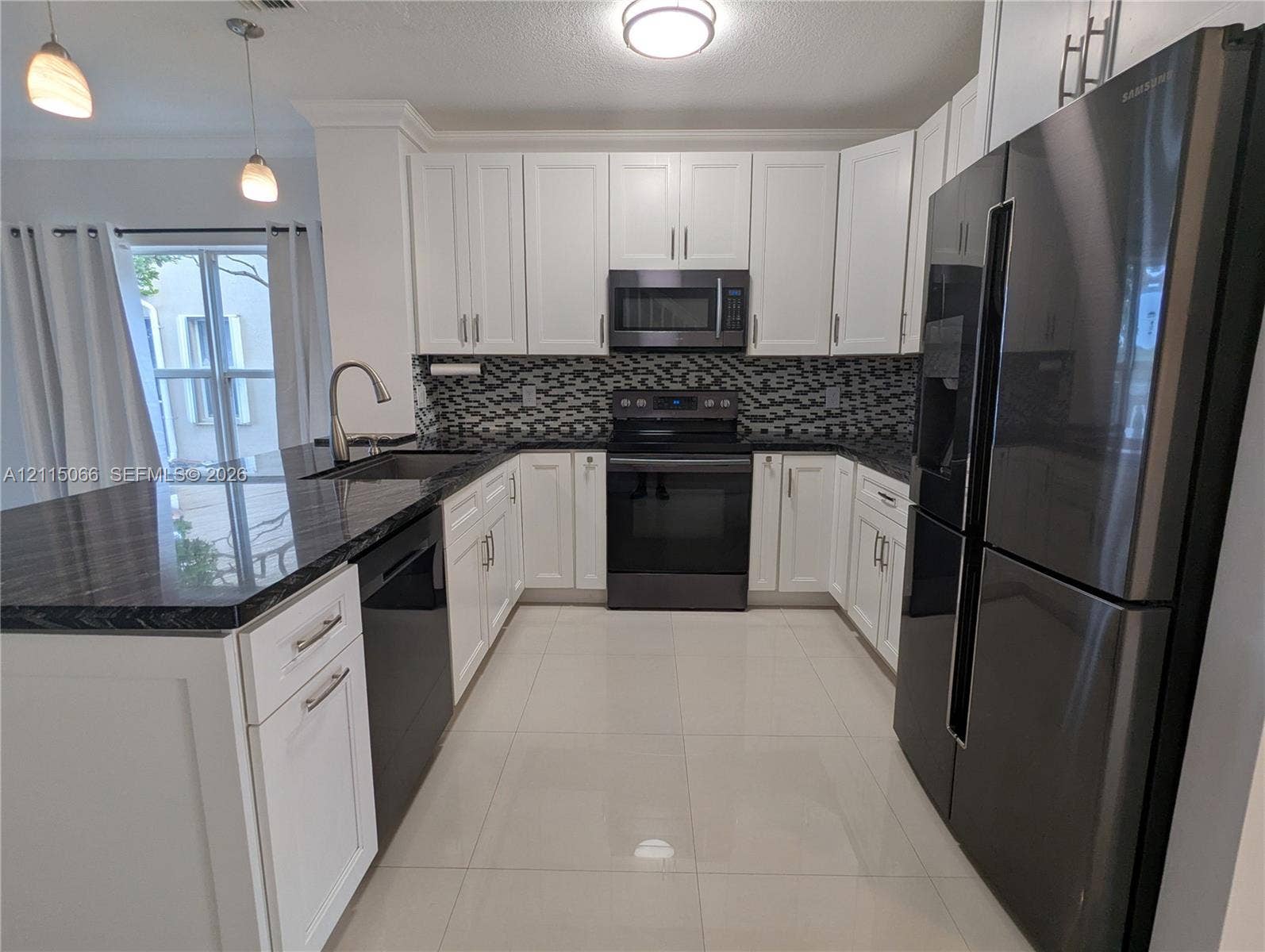 215 SW 120th Avenue, #215, Pembroke Pines, Pembroke Pines, FL 33025 Kitchen featuring white cabinetry, dark stone countertops, patterned tile backsplash, stainless steel appliances, and large-format tile flooring