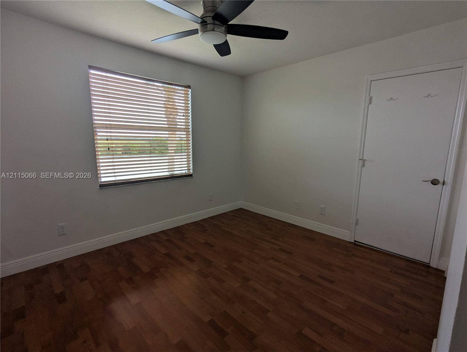 215 SW 120th Avenue, #215, Pembroke Pines, Pembroke Pines, FL 33025 Room featuring wood-finish flooring, a multi-blade ceiling fan with integrated lighting, and a window with horizontal blinds