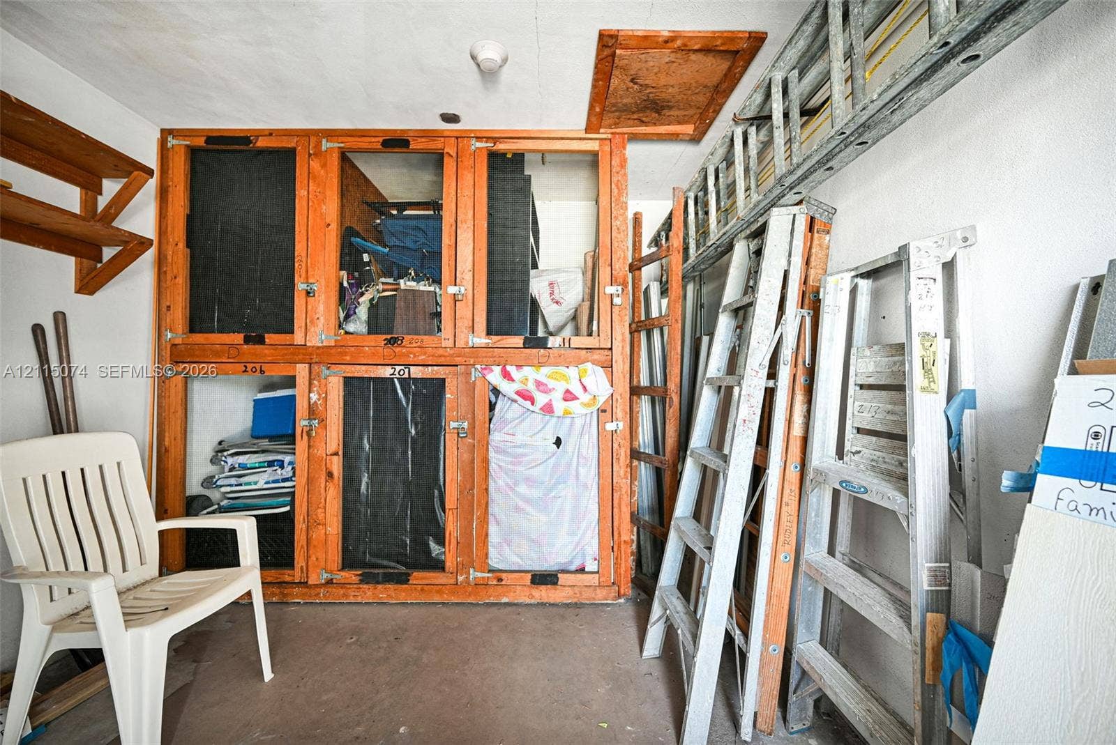 Custom-built wooden storage compartments featuring integrated latches and upper-level attic access panel