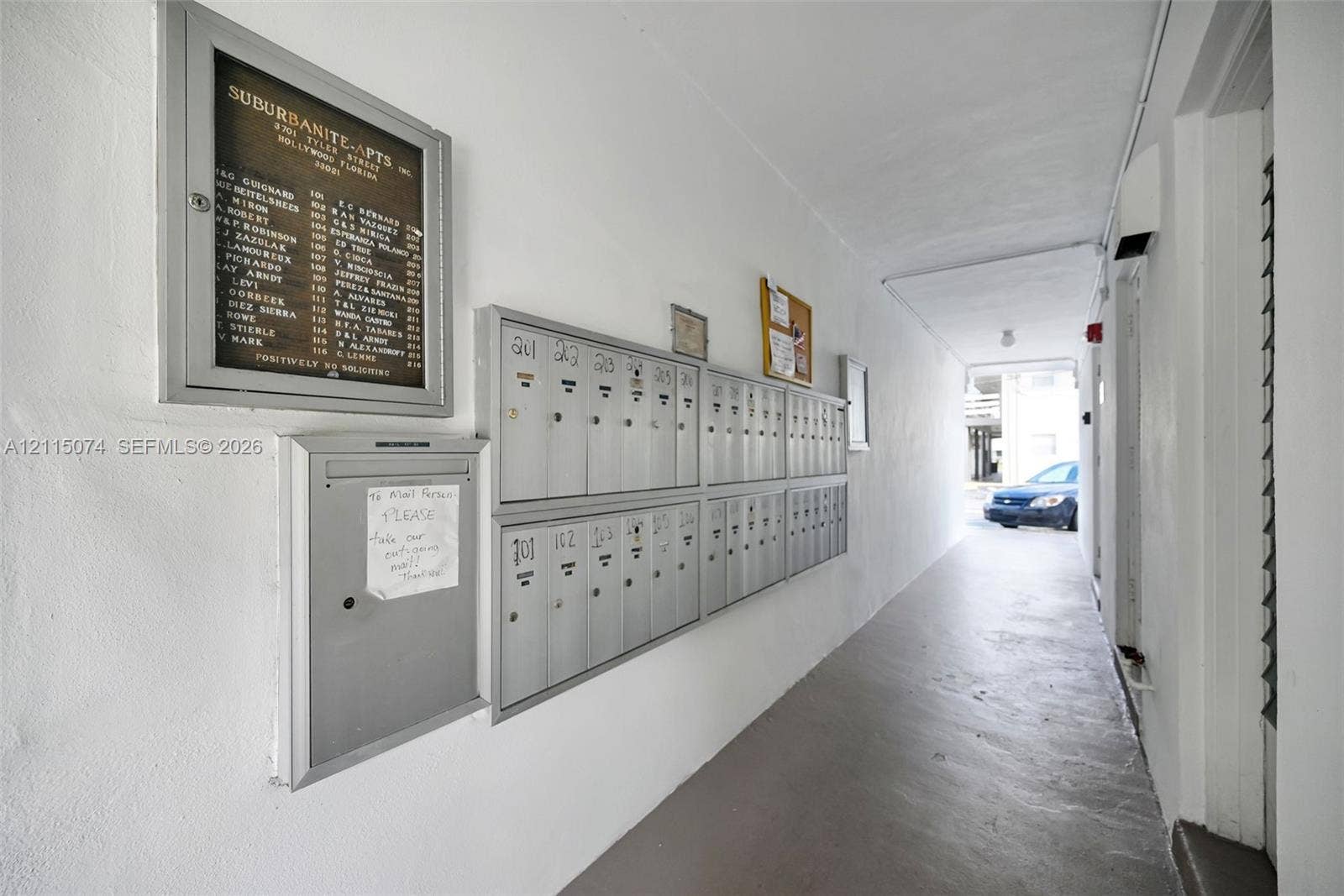 Covered corridor featuring metal mailboxes and a wall-mounted building directory