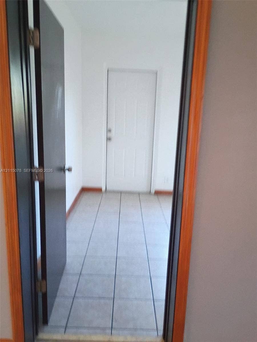 209 SW 12th Street, #A, Dania, Dania Beach, FL 33004 Square tile flooring, white six-panel door, and natural wood-finish door casing