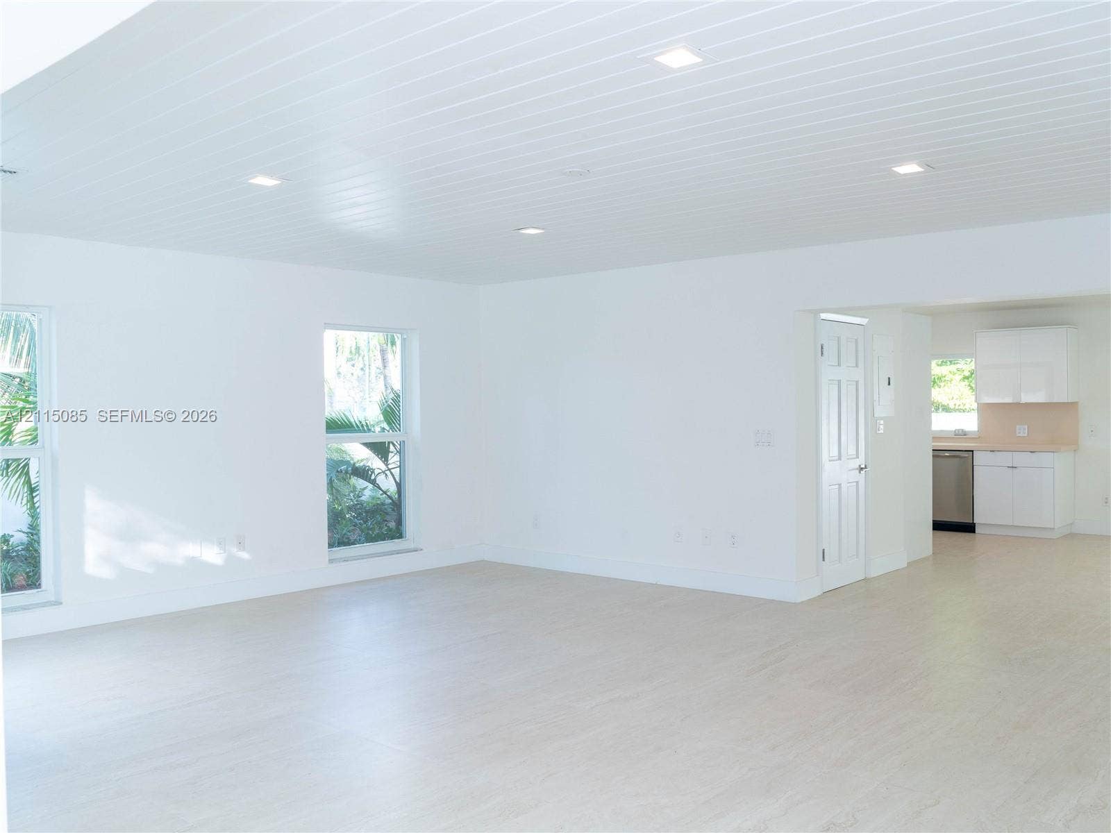 663 Woodcrest Road, Key Biscayne, Key Biscayne, FL 33149 Open-concept interior featuring light-toned porcelain tile flooring, tongue-and-groove ceiling with recessed lighting, double-hung windows, and white cabinetry
