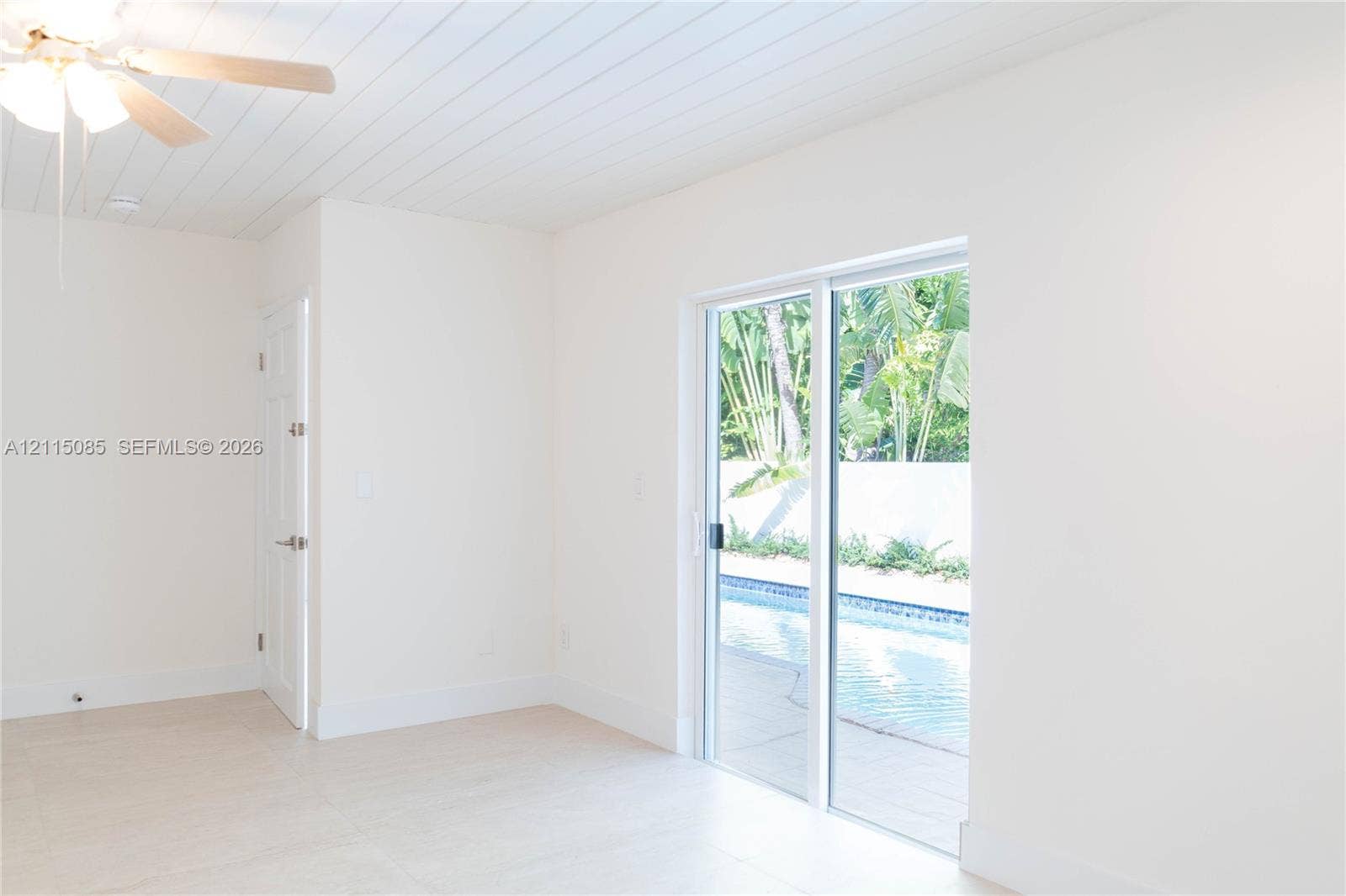 663 Woodcrest Road, Key Biscayne, Key Biscayne, FL 33149 Room featuring a beadboard ceiling, light-toned porcelain tile flooring, ceiling fan with integrated lighting, and sliding glass doors with direct exterior access to a pool