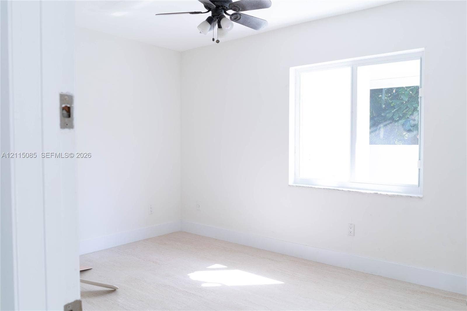 663 Woodcrest Road, Key Biscayne, Key Biscayne, FL 33149 Neutral interior space featuring light-toned porcelain tile flooring, a ceiling fan with integrated lighting, and a sliding window