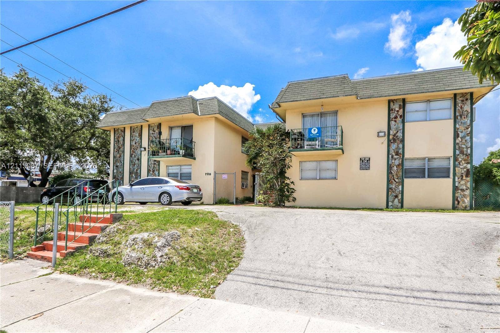 720 NW 27th Court, #18, Miami, Miami, FL 33125 Two-story building featuring masonry facade detailing, shingled mansard roof lines, and upper-level balconies with metal railings