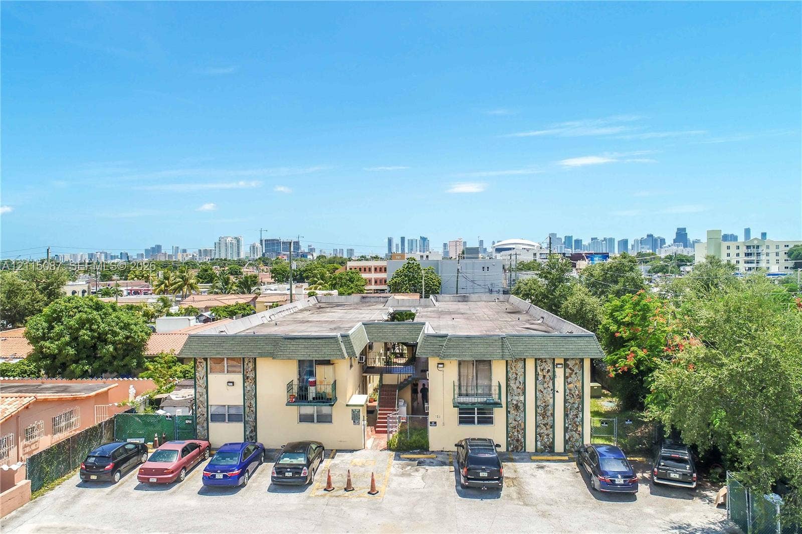 720 NW 27th Court, #18, Miami, Miami, FL 33125 Two-story multifamily property featuring decorative stone exterior accents, individual unit balconies, and dedicated surface parking