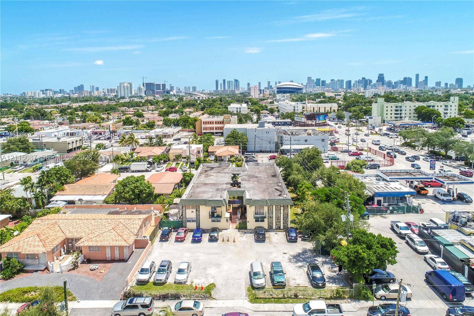 720 NW 27th Court, #18, Miami, Miami, FL 33125 Aerial perspective of a multi-unit property featuring a flat roof structure, masonry exterior, and dedicated surface parking
