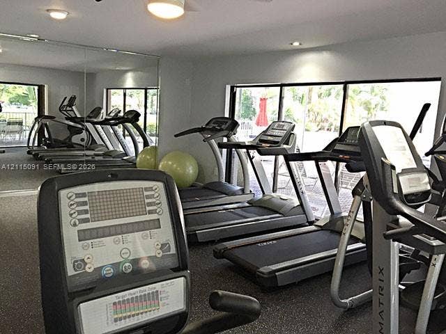 7715 SW 86th Street, #A2-402, Miami, Miami, FL 33143 Fitness center featuring wall-to-wall mirrors, recessed lighting, rubberized flooring, and expansive floor-to-ceiling glass doors