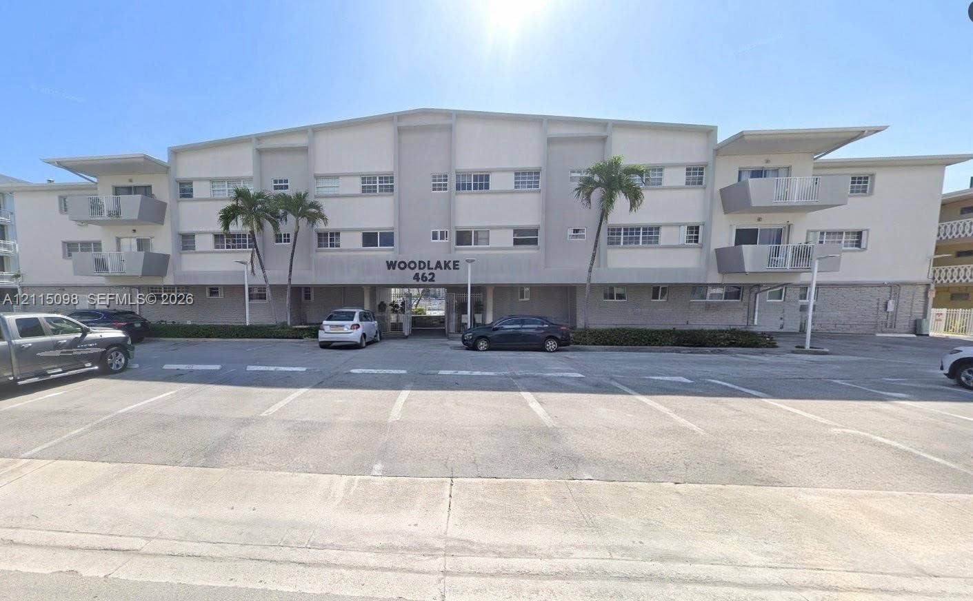 462 Golden Isles Drive, #306, Hallandale Beach, Hallandale Beach, FL 33009 Multi-story exterior featuring a neutral stucco facade, private cantilevered balconies, and paved surface parking