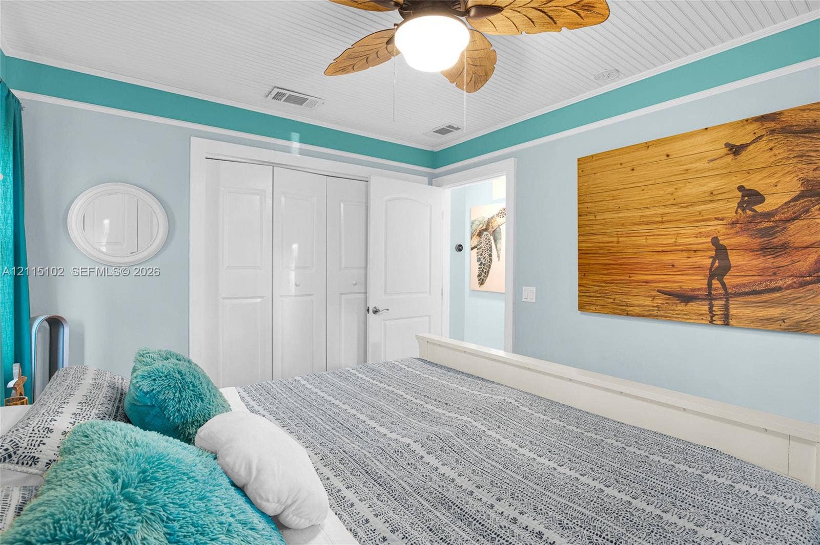 110 S Peninsula, New Smyrna Beach, FL 32169 Beadboard ceiling featuring a central palm-style ceiling fan, bi-fold closet doors, and multi-panel interior door