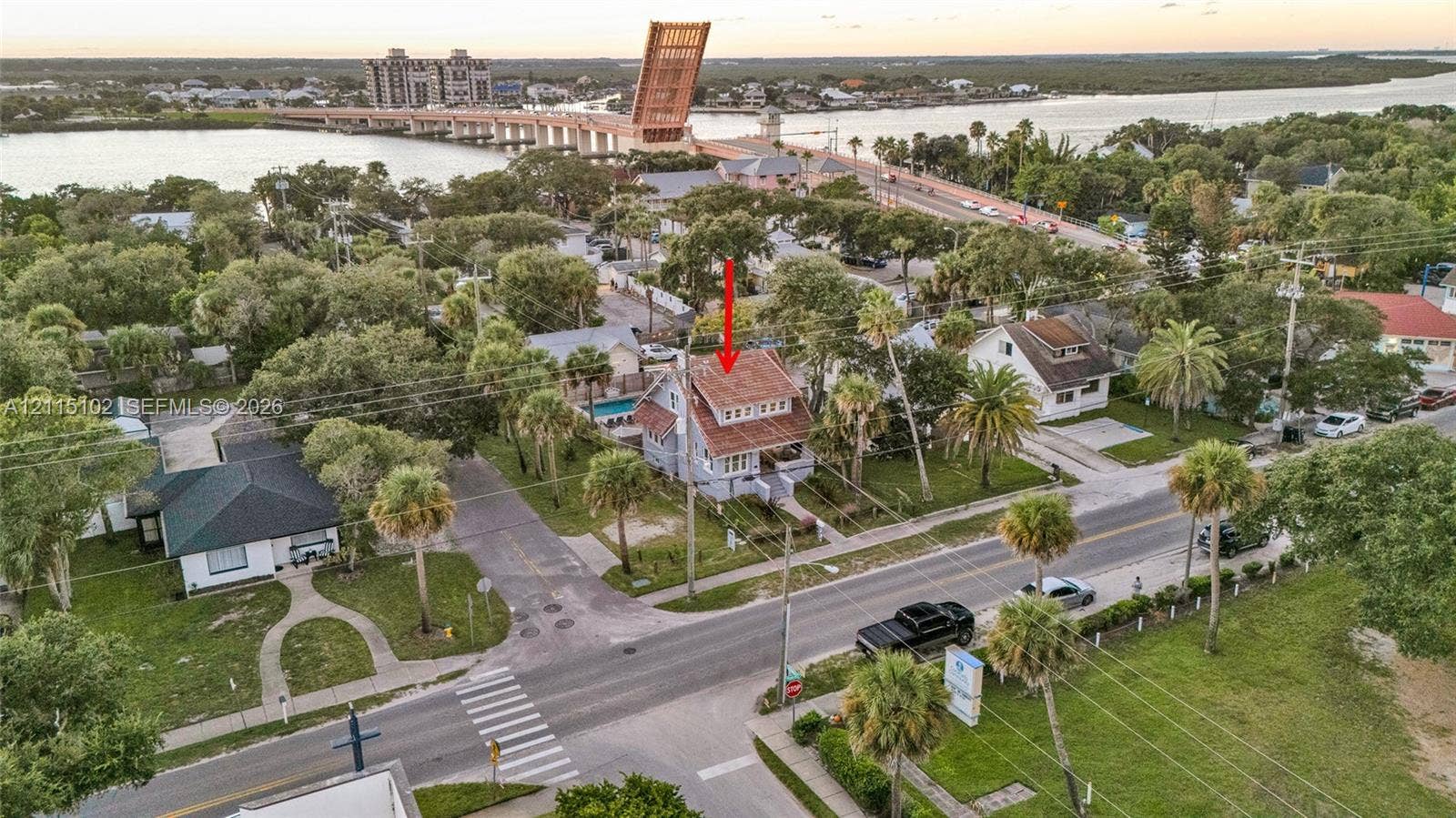 110 S Peninsula, New Smyrna Beach, FL 32169 Two-story residence featuring a shingled roof, exterior staircases, and a private rear swimming pool, situated on a corner lot with mature palm trees