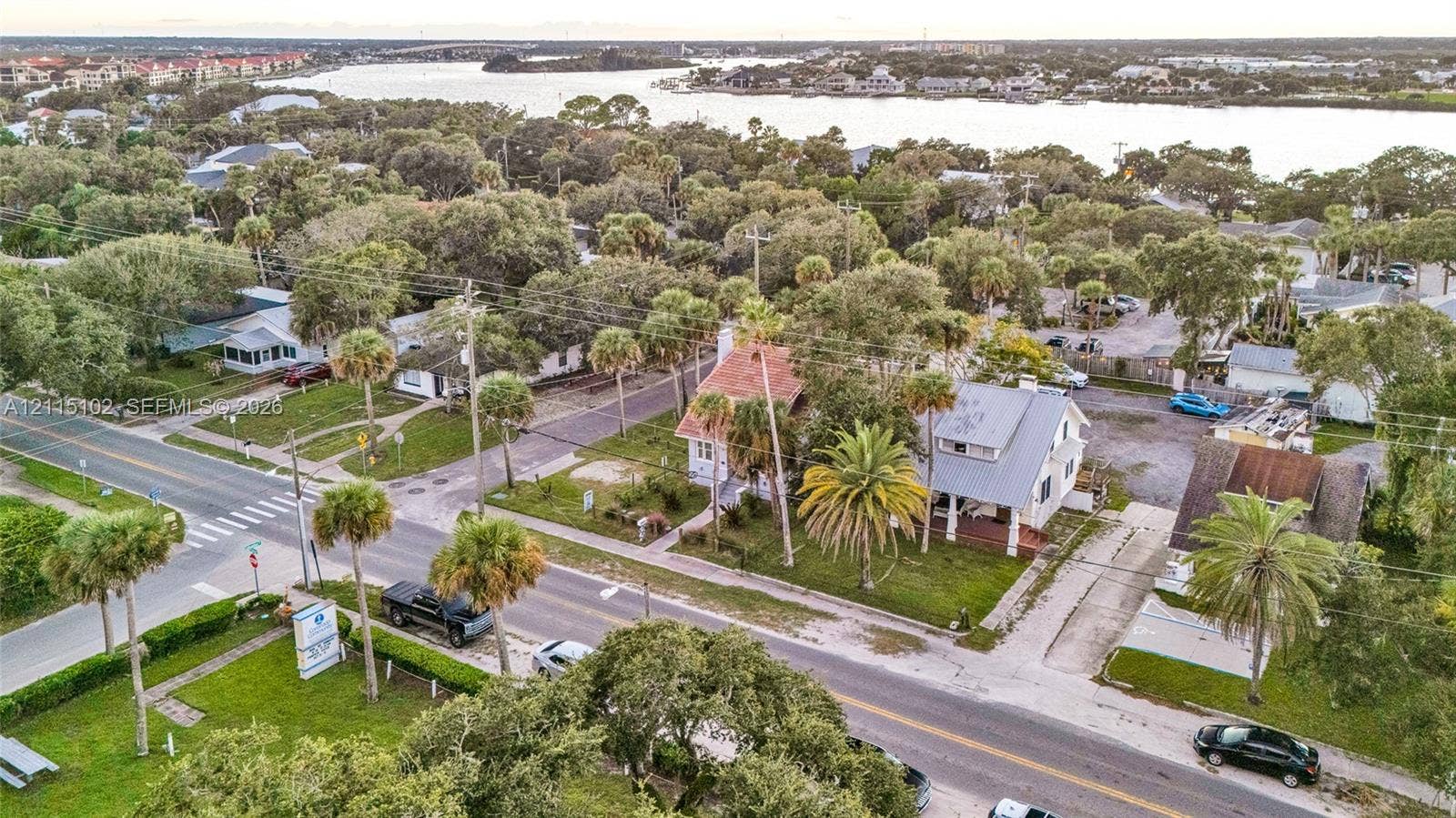 110 S Peninsula, New Smyrna Beach, FL 32169 Aerial perspective of the property featuring mature landscaping, palm trees, and proximity to the waterfront