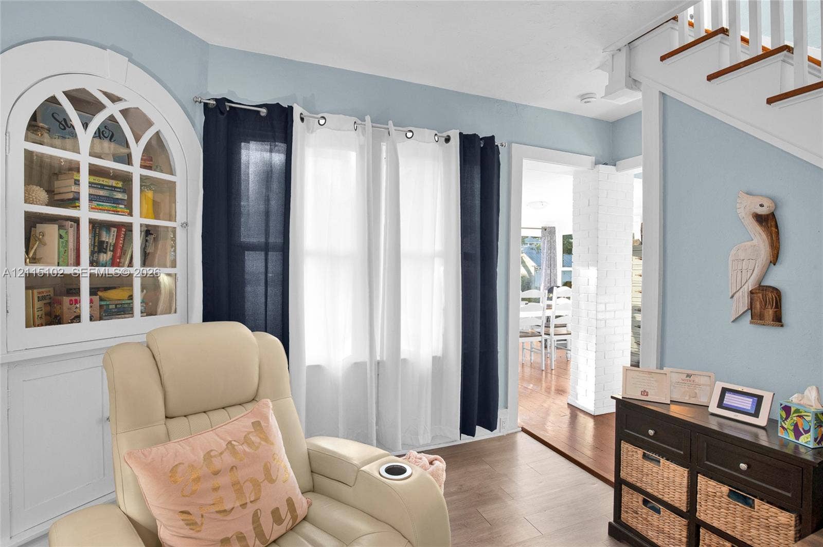 110 S Peninsula, New Smyrna Beach, FL 32169 Arched built-in display cabinetry, wood-finish flooring, and a white-painted brick structural column