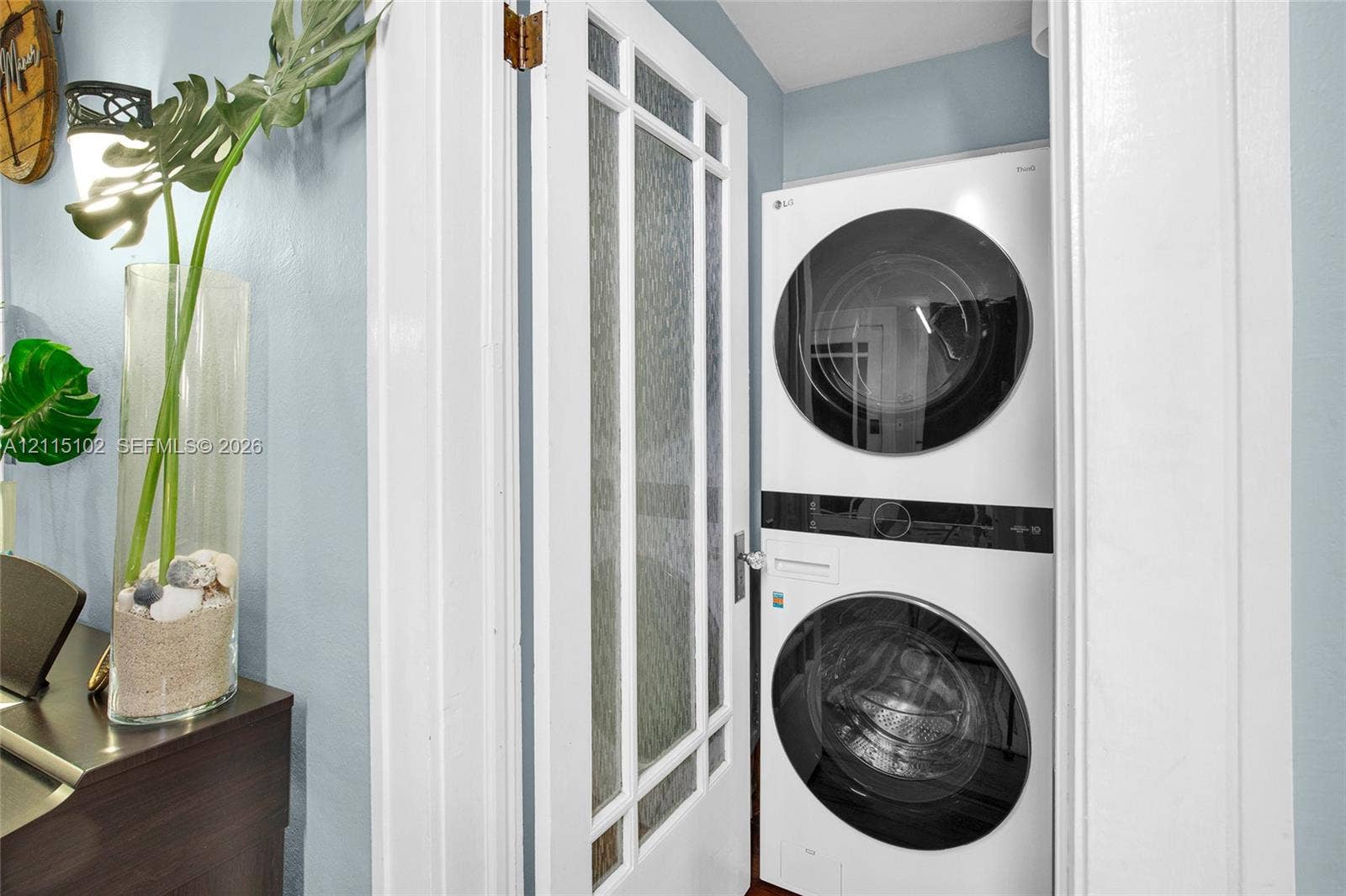 110 S Peninsula, New Smyrna Beach, FL 32169 Stacked washer and dryer unit concealed behind a white door with textured glass panels