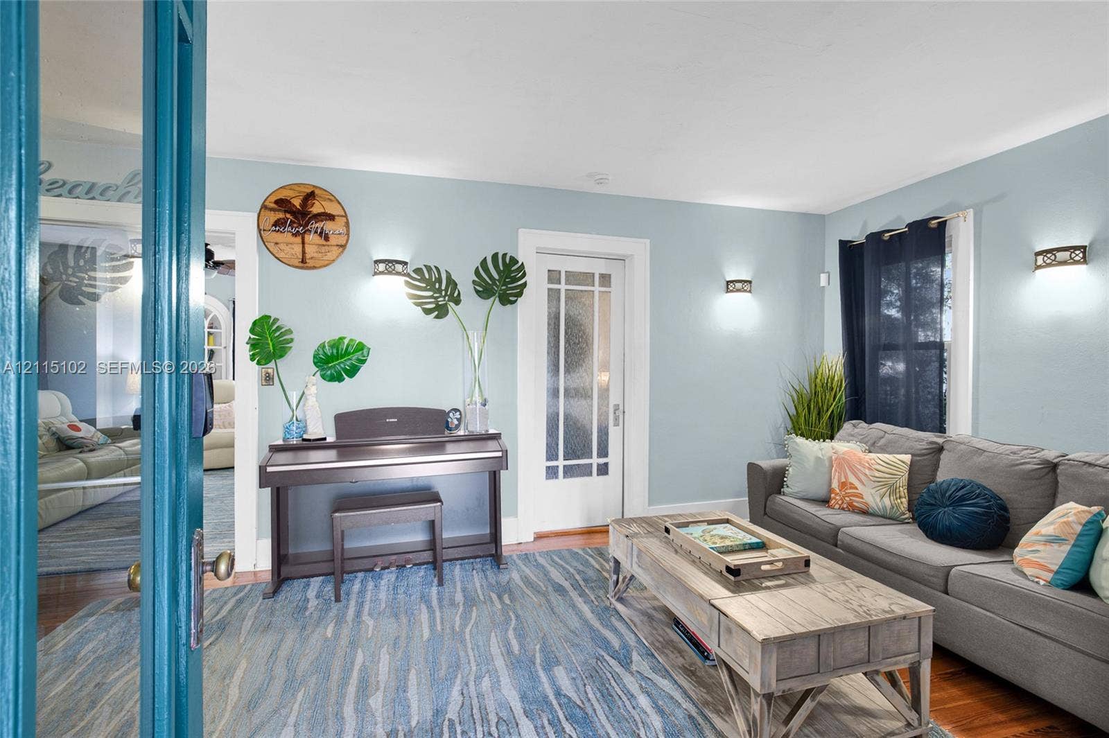 110 S Peninsula, New Smyrna Beach, FL 32169 Interior space featuring hardwood flooring, glass-paned French doors, and wall-mounted sconce lighting