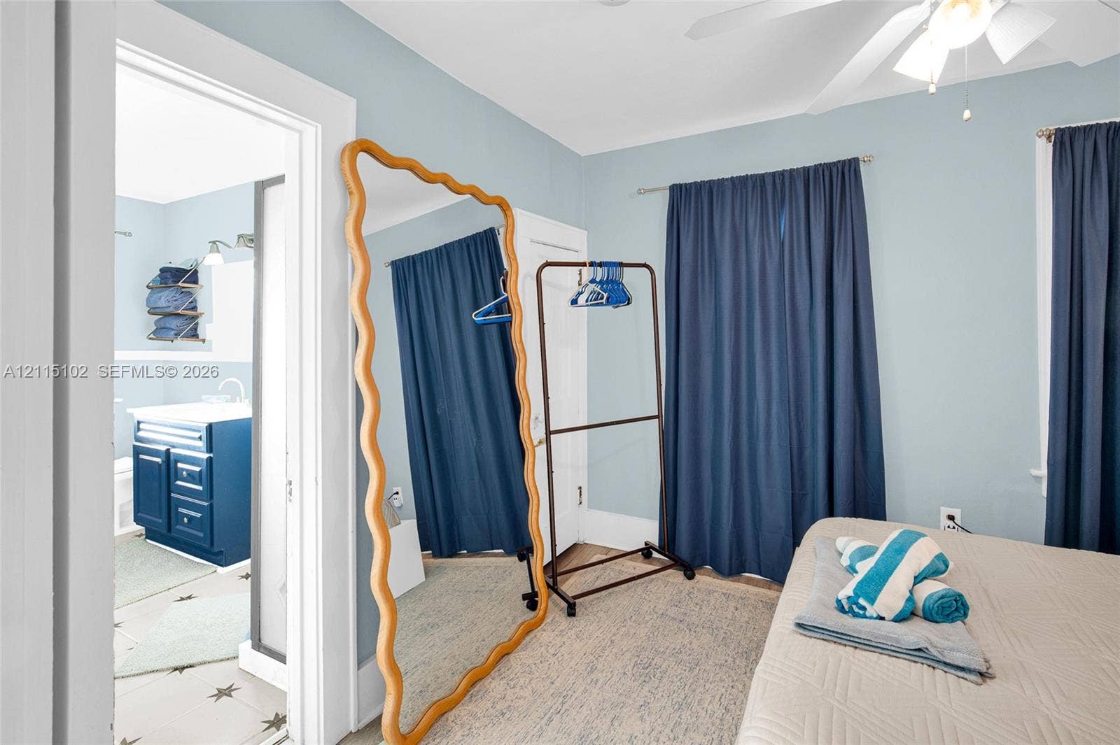 110 S Peninsula, New Smyrna Beach, FL 32169 Bedroom featuring a ceiling-mounted light fixture with fan and wall-to-wall drapery hardware