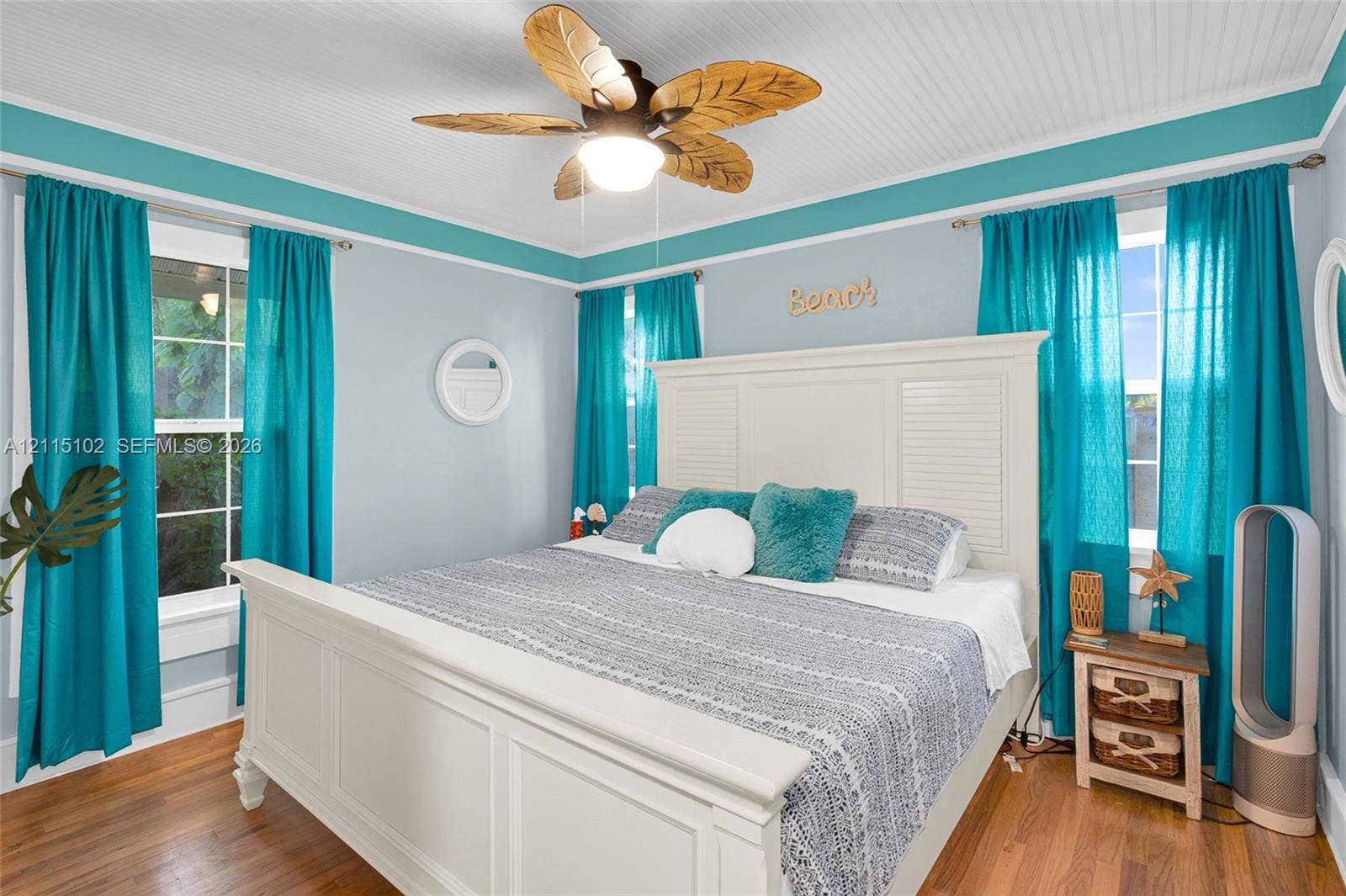 110 S Peninsula, New Smyrna Beach, FL 32169 Beadboard ceiling featuring a paddle-style ceiling fan with integrated lighting, wood-finish flooring, and multi-pane windows