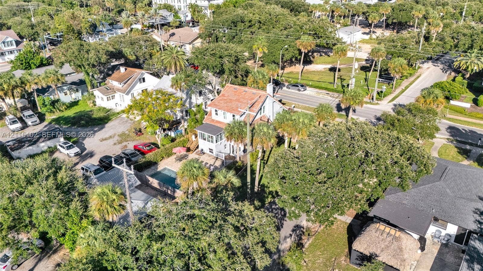 110 S Peninsula, New Smyrna Beach, FL 32169 Aerial perspective featuring an in-ground swimming pool, masonry hardscaping, mature palm trees, and multi-level residential architecture