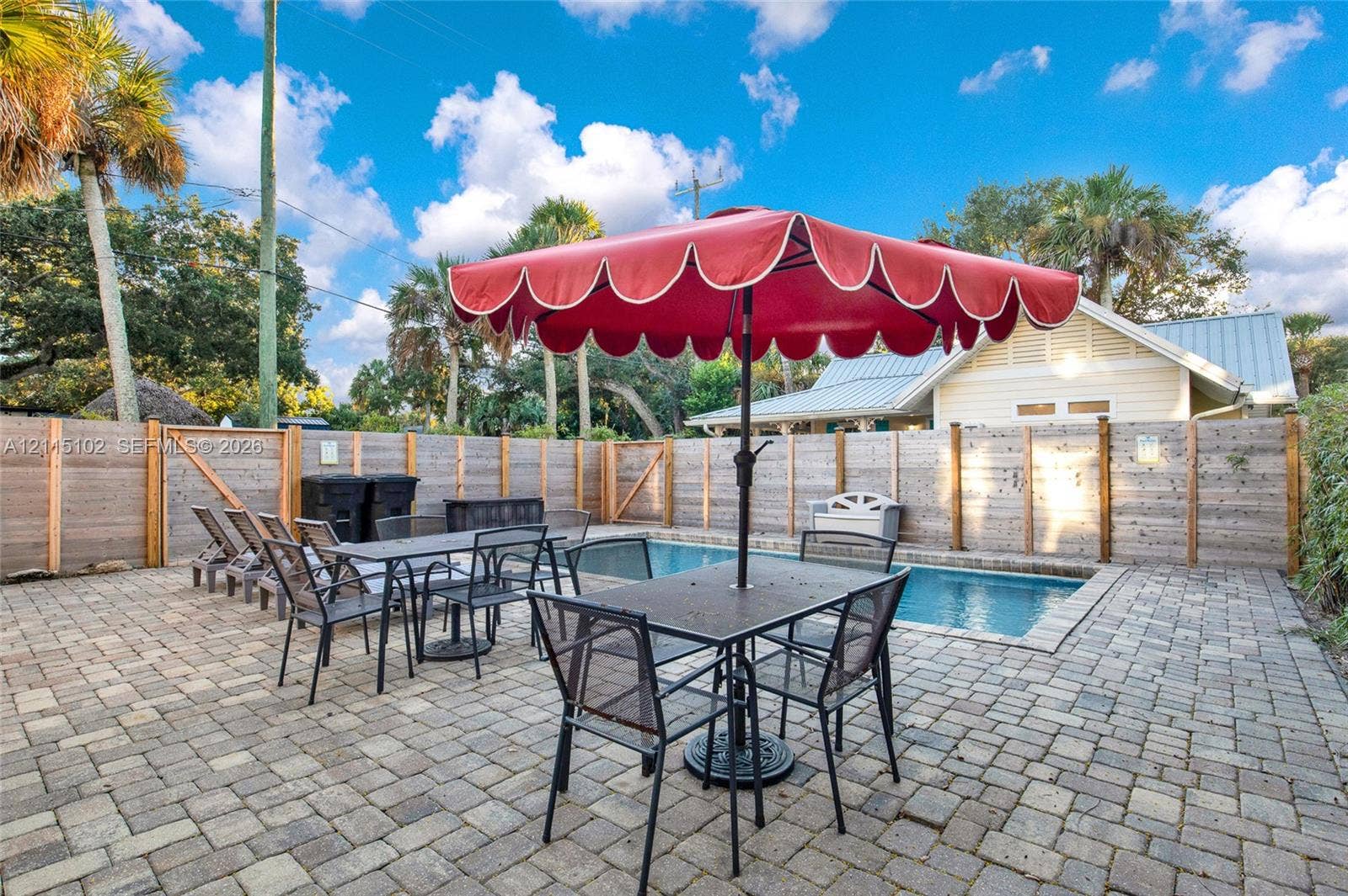 110 S Peninsula, New Smyrna Beach, FL 32169 In-ground swimming pool surrounded by a paver patio and horizontal wood privacy fencing