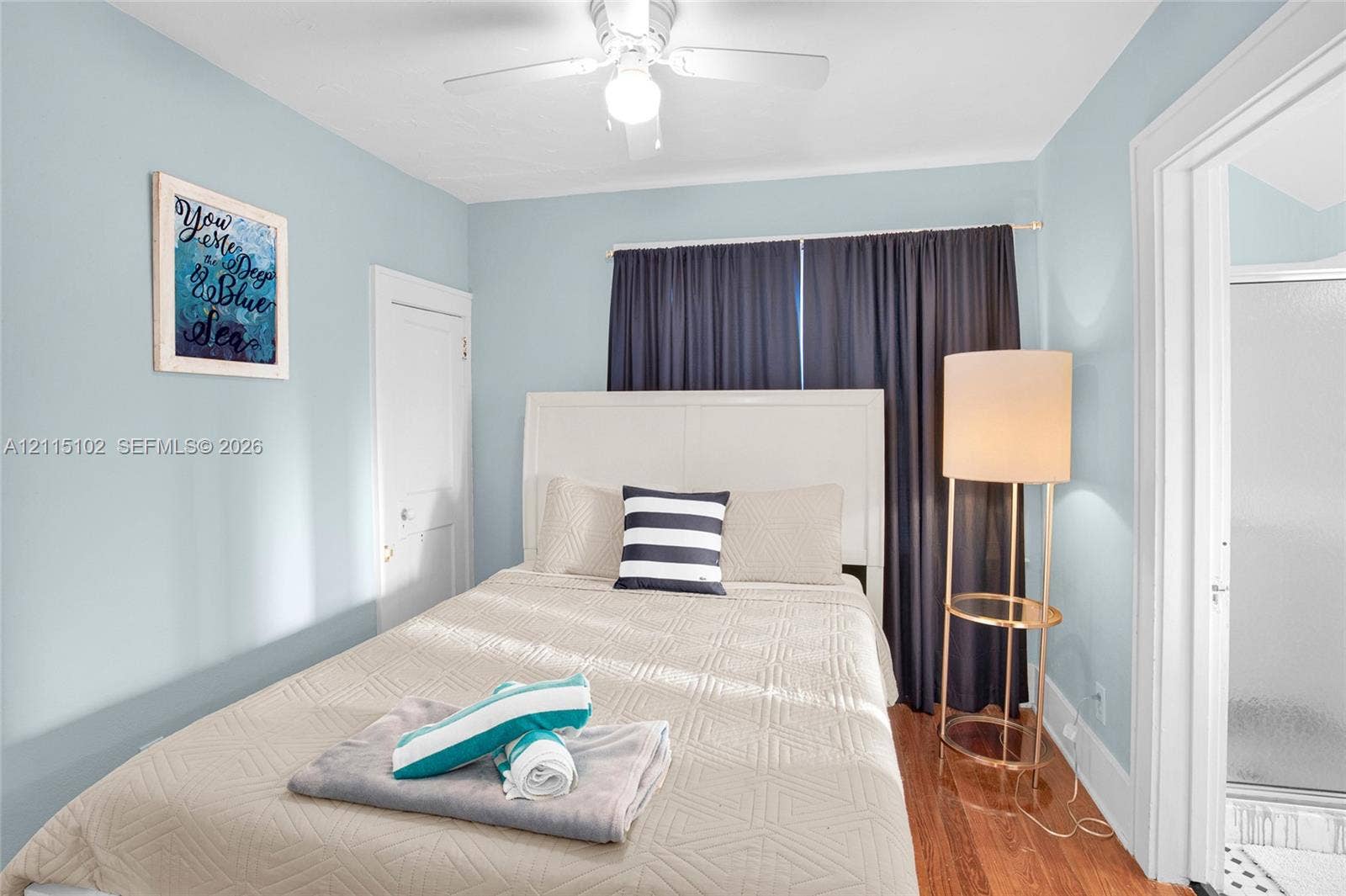 110 S Peninsula, New Smyrna Beach, FL 32169 Interior space featuring hardwood flooring, multi-panel interior door, and ceiling-mounted light fixture with fan