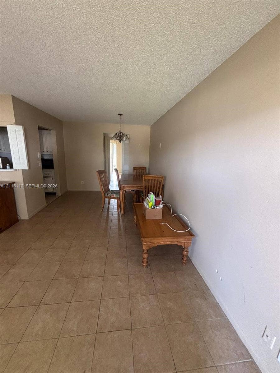 89 Andover D, #89, West Palm Beach, West Palm Beach, FL 33417 Interior space featuring neutral-toned walls, tile flooring, and a decorative overhead light fixture