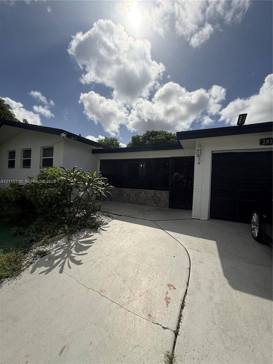 2816 SW 4th Place, #A, Fort Lauderdale, Fort Lauderdale, FL 33312 Single-story exterior featuring white masonry facade, stone accent detailing, dark-toned trim, and an attached garage