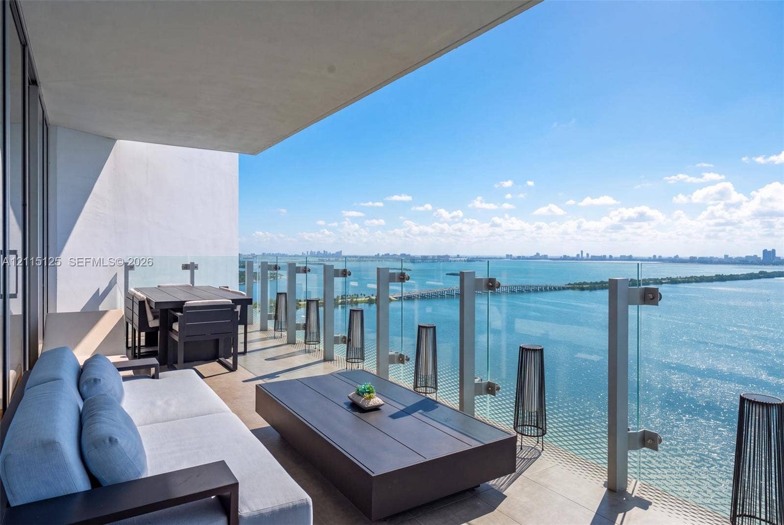 Covered balcony featuring tile flooring and a transparent glass panel railing