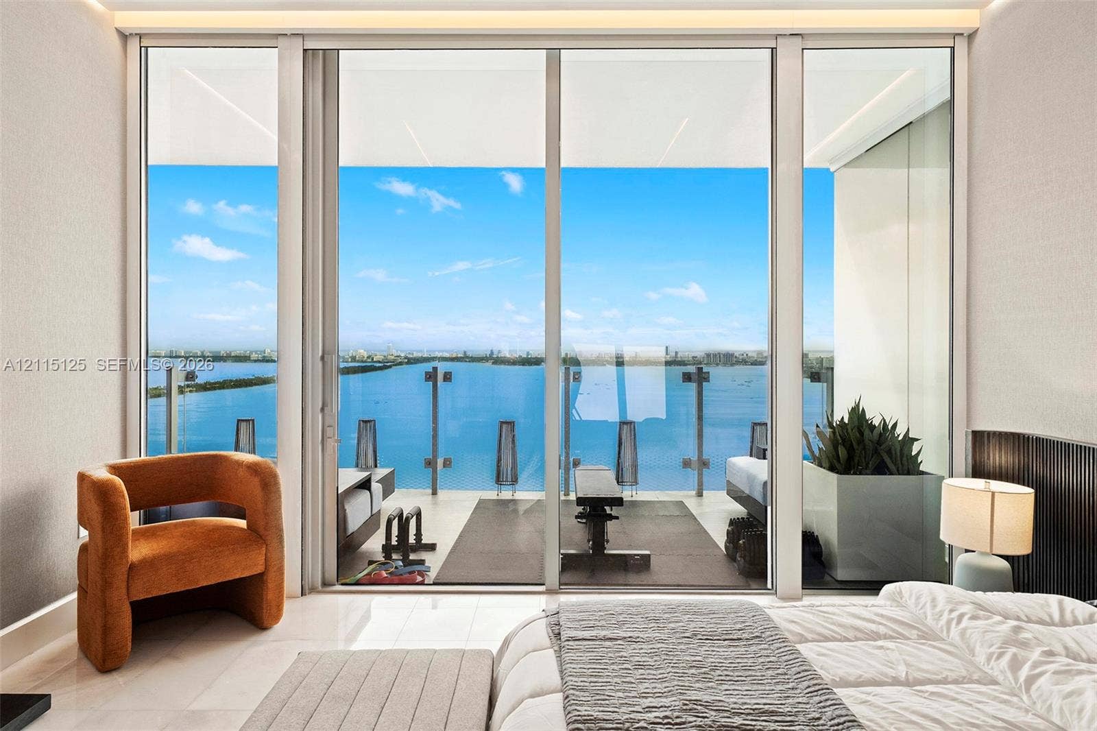 Floor-to-ceiling glass sliding doors, private balcony with glass railings, polished stone flooring, and built-in recessed ceiling lighting
