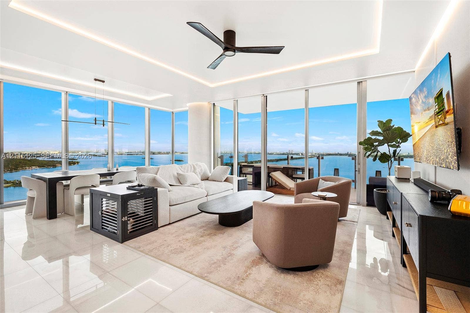 Floor-to-ceiling glass windows, recessed ceiling cove lighting, polished tile flooring, and matte black modern ceiling fan