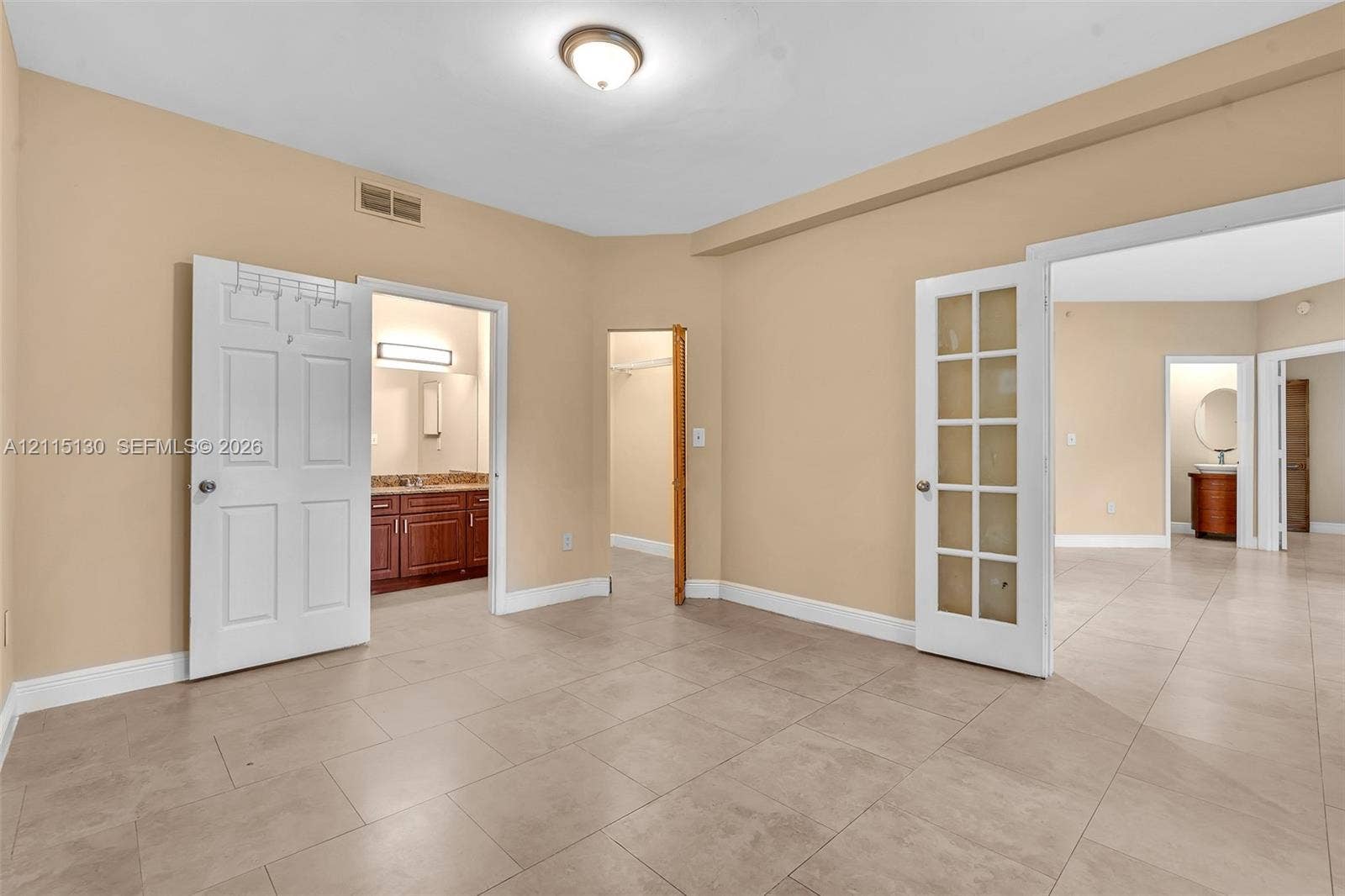 2445 SW 18th Terrace, #412, Fort Lauderdale, FL 33315 Neutral-toned tile flooring, white six-panel interior doors, and a glass-paneled French door