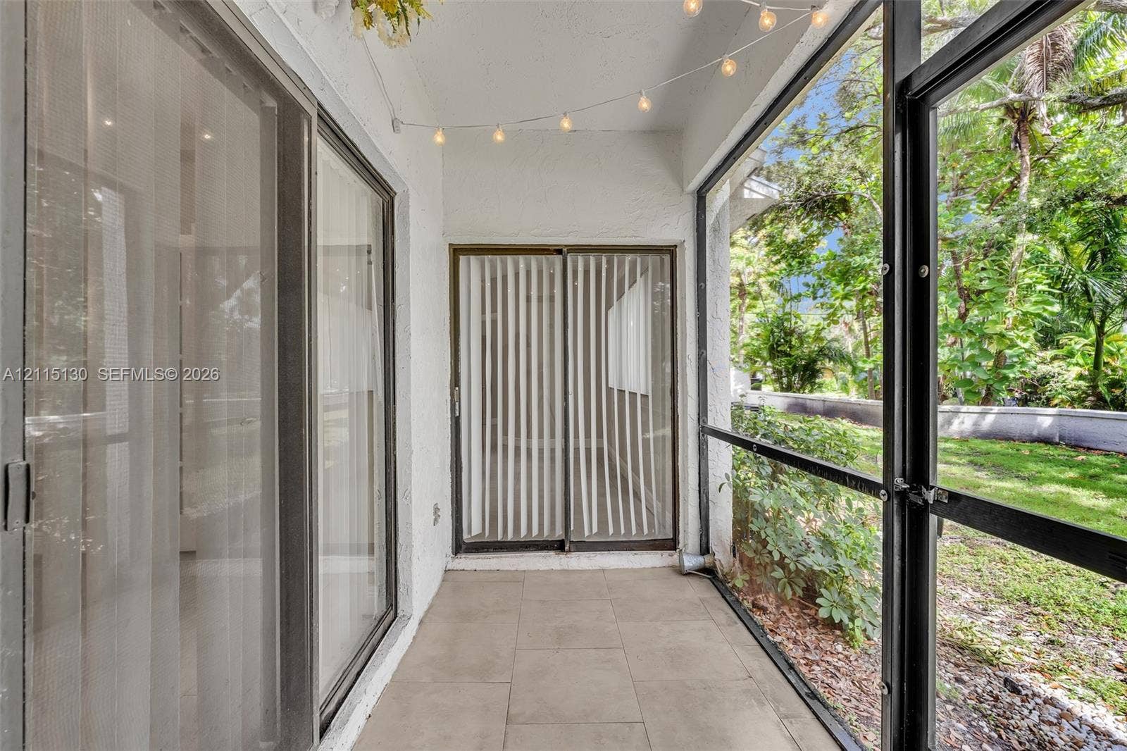2445 SW 18th Terrace, #412, Fort Lauderdale, FL 33315 Screened-in patio featuring tile flooring, sliding glass door access, and exterior metal framing
