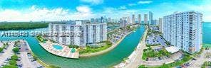 400 Kings Point Drive, #317, Sunny Isles Beach, FL 33160 Aerial perspective featuring waterfront residential buildings, a paved swimming pool deck, canal access, and surface parking areas