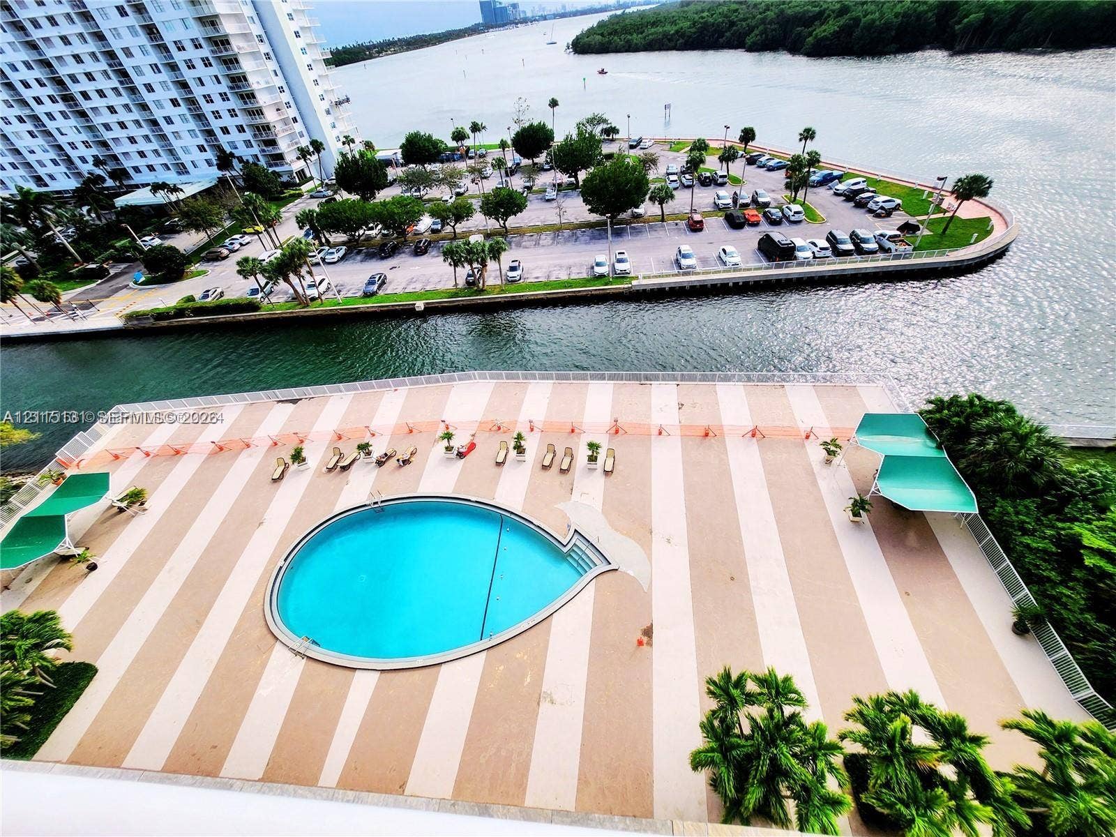 400 Kings Point Drive, #317, Sunny Isles Beach, FL 33160 Outdoor pool deck featuring a circular swimming pool, paved surface, and two shaded structures