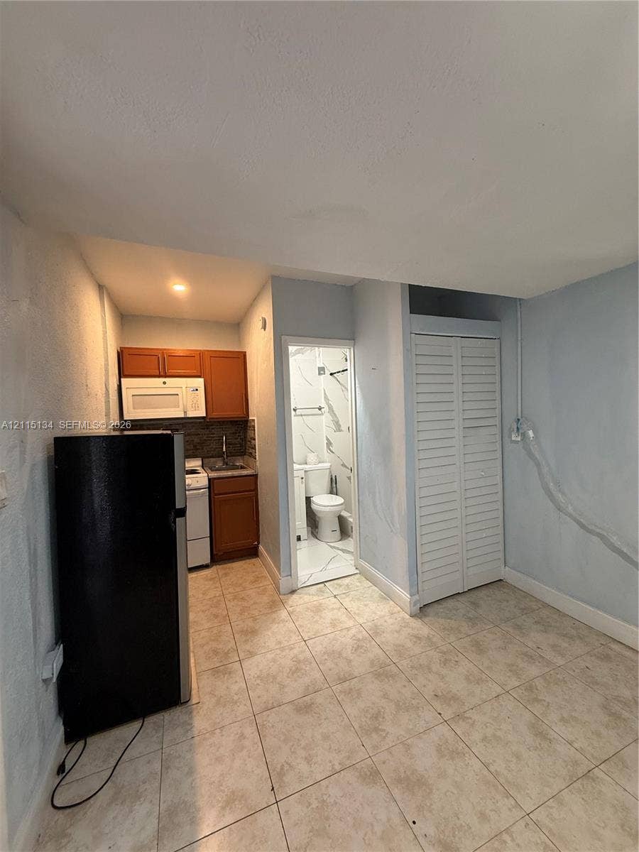 2816 SW 4th Place, #B, Fort Lauderdale, Fort Lauderdale, FL 33312 Kitchenette featuring wood-finish cabinetry, over-the-range microwave, white range, and ceramic tile flooring