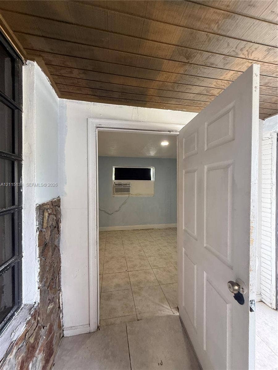 2816 SW 4th Place, #B, Fort Lauderdale, Fort Lauderdale, FL 33312 Exterior entry area featuring a natural stone accent wall, wood-plank ceiling, and tile flooring