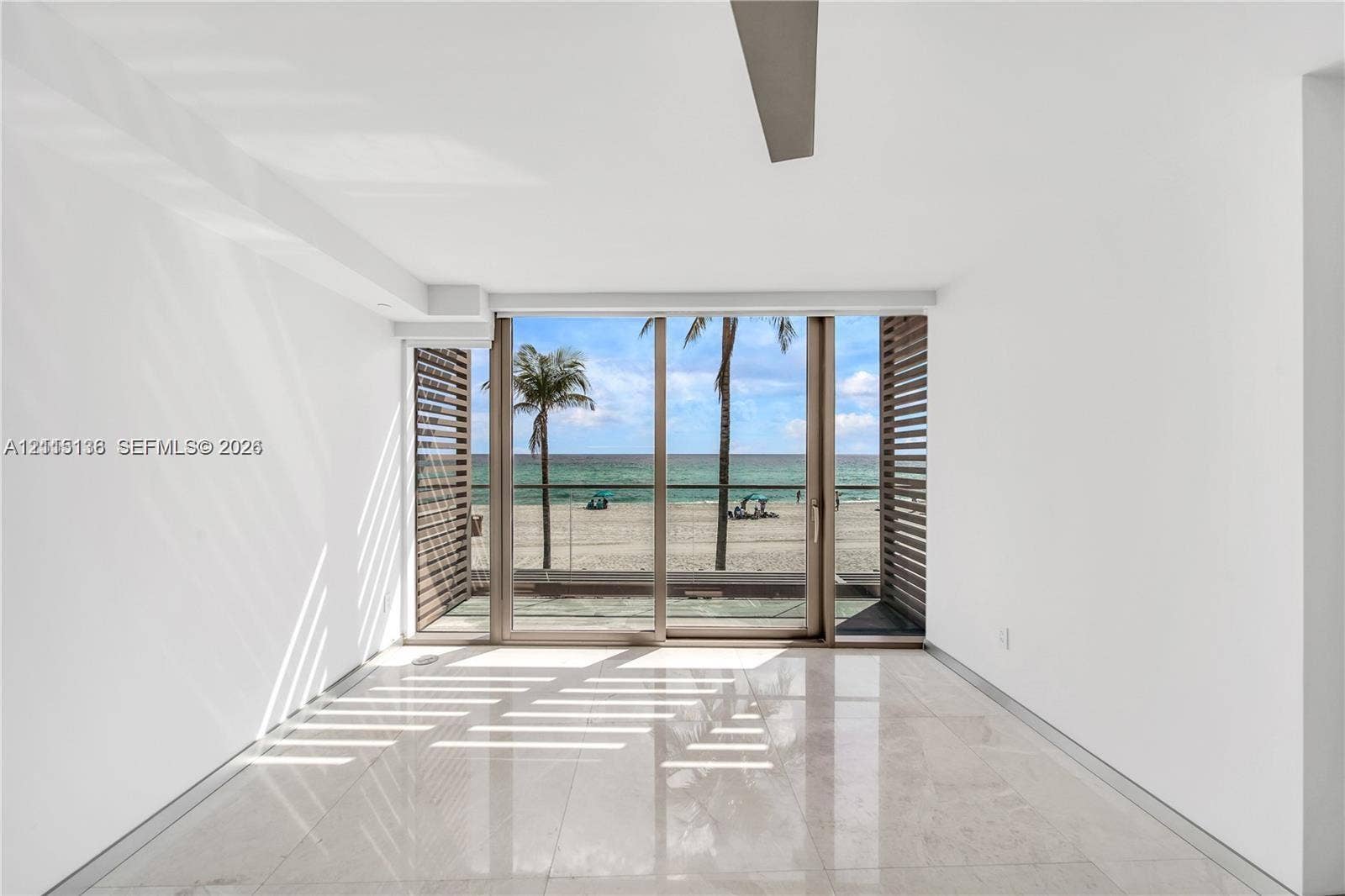18975 Collins Avenue, #CABANA 20, Sunny Isles Beach, FL 33160 Floor-to-ceiling sliding glass doors, polished stone flooring, custom slatted wood screening, and a recessed ceiling fan