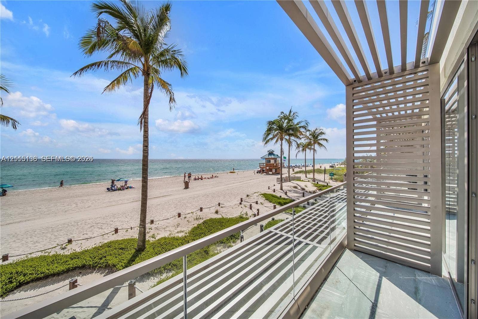 18975 Collins Avenue, #CABANA 20, Sunny Isles Beach, FL 33160 Private balcony featuring a glass panel railing, overhead slatted architectural screen, and stone flooring, oriented toward a coastal setting