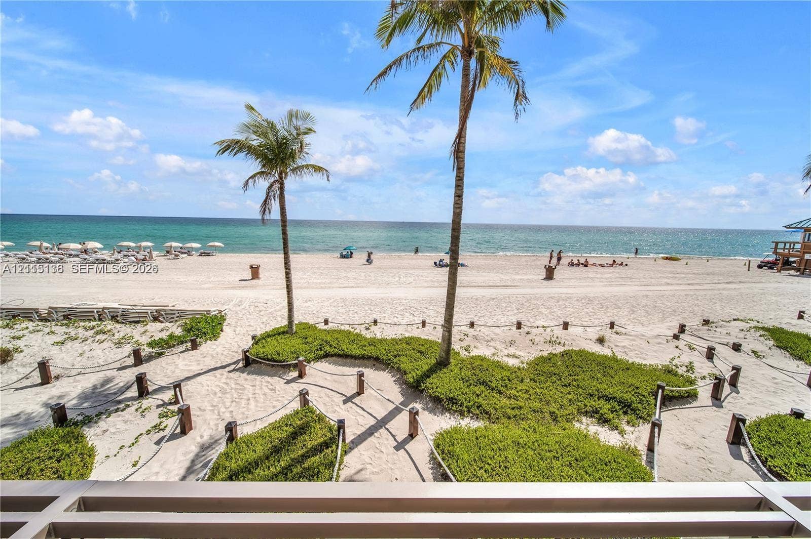 18975 Collins Avenue, #CABANA 20, Sunny Isles Beach, FL 33160 Direct oceanfront exposure featuring expansive sandy shoreline, established palm trees, rope-bordered landscaping, and horizontal railing