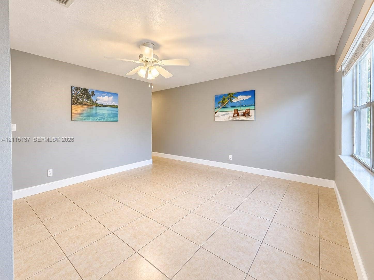 7870 SW 10th Court, #A, North Lauderdale, North Lauderdale, FL 33068 Interior space featuring neutral wall paint, tile flooring, white-finish ceiling fan with integrated lighting, and a multi-pane window